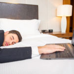 Man on bed asleep with computer
